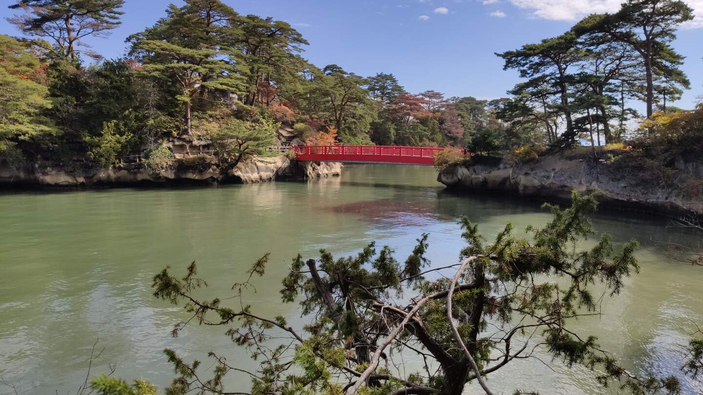 Blick auf eine der vielen vorgelagerten Inseln, mit typischen japanischen Krüppelkiefern bewachsen, in der Japanischen See mit roterBrücke in Matsushima, Japan | © Jens Hinsche