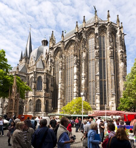 Menschen auf einem Bauernmarkt vor dem Aachener Dom | © Gettyimages.com/eyewave
