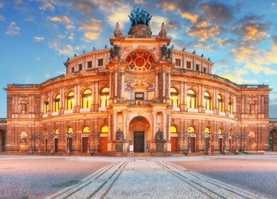 Frontansicht der Semperoper Dresden am Theaterplatz in abendlich festlicher Beleuchtung | © Gettyimages.com/TomasSereda
