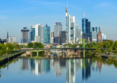 Skyline von Frankfurt und Reflexion im Main an einem sonnigen Tag | © Gettyimages.com/Deejpilot