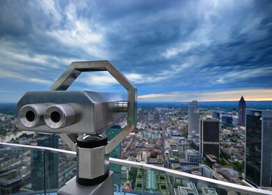 Frankfurter Stadtbild bei Sonnenuntergang. Ausblick mit Fernglas vom Main Tower | © Gettyimages.com/ChrisHepburn