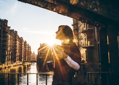 Frau in der Speciherstadt von Hamburg bei Sonnenschein | © Gettyimages.com/urbazon