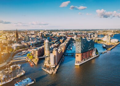 Luftaufnahme der Hamburger Hafenstadt ueber dem blauen Hafen  | © Gettyimages.com/Nikada