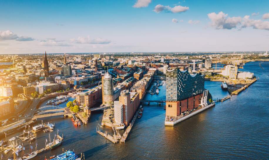 Luftaufnahme der Hamburger Hafenstadt ueber dem blauen Hafen  | © Gettyimages.com/Nikada
