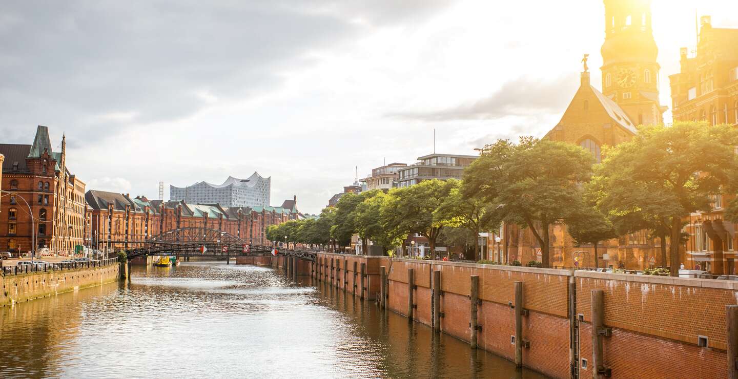 Wunderschoener Stadtblick auf den Wasserkanal mit alter Kirche in Hamburg-Stadt waehrend des Sonnenuntergangs | © gettyimages.com/RossHelen
