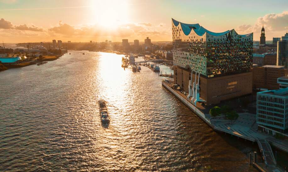 Luftaufnahme vom Wasser auf der Hamburger Hafenstadt mit der Elbphilharmonie zur goldenen Stunde | © Gettyimages.com/golero