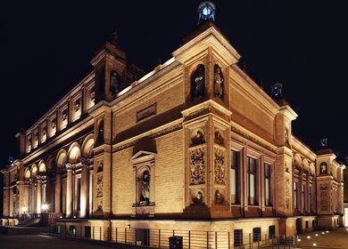Die beleuchtete Fassade des historischen Teils der Hamburger Kunsthalle bei Nacht in einem seitlichen Blickwinkel | © GettyImages.com/Fitzer