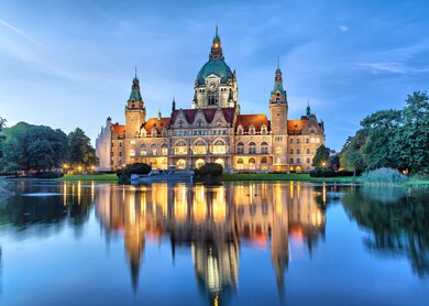Blick auf beleuchtete Neue Rathause in Hannover am Abend mit See im Vordergrund  | © Gettyimages.com/bbsferrari