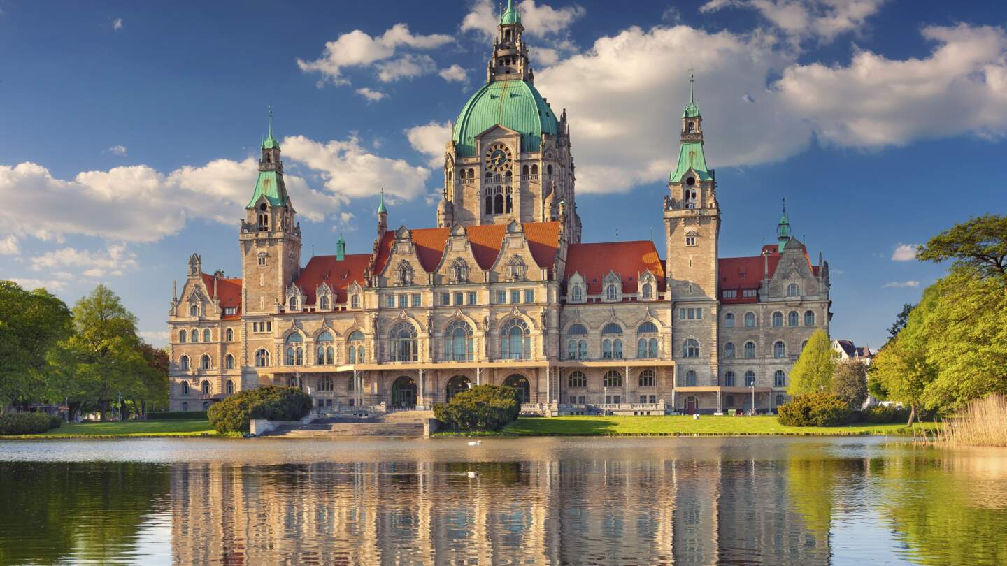 Blick auf Neue Rathause in Hannover mit See im Vordergrund und blauem Himmel im Fruehling | © Gettyimages.com/RudyBalasko