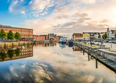 Blick auf den Hafen von Husum, Schleswig-Holstein, in warmen Sonnenlicht mit Spiegelung auf dem Wasser | © Gettyimages.com/bluejayphoto