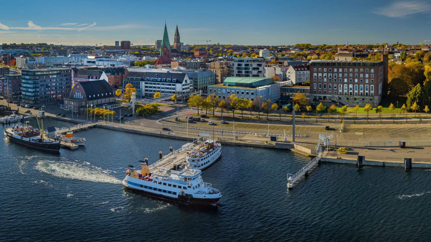 Panorama der Kieler Innenstadt und des Hafens mit Linienfaehre. Kieler Foerdemuseum Hafen im Vordergrund, im Hintergrund das Kieler Schloss. | © Gettyimages.com/frederickdoerschem