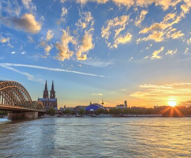 Skyline von Köln mit Kölner Dom und Rhein im Sonnenuntergang | © Gettyimages.com/Noppasin Wongchum