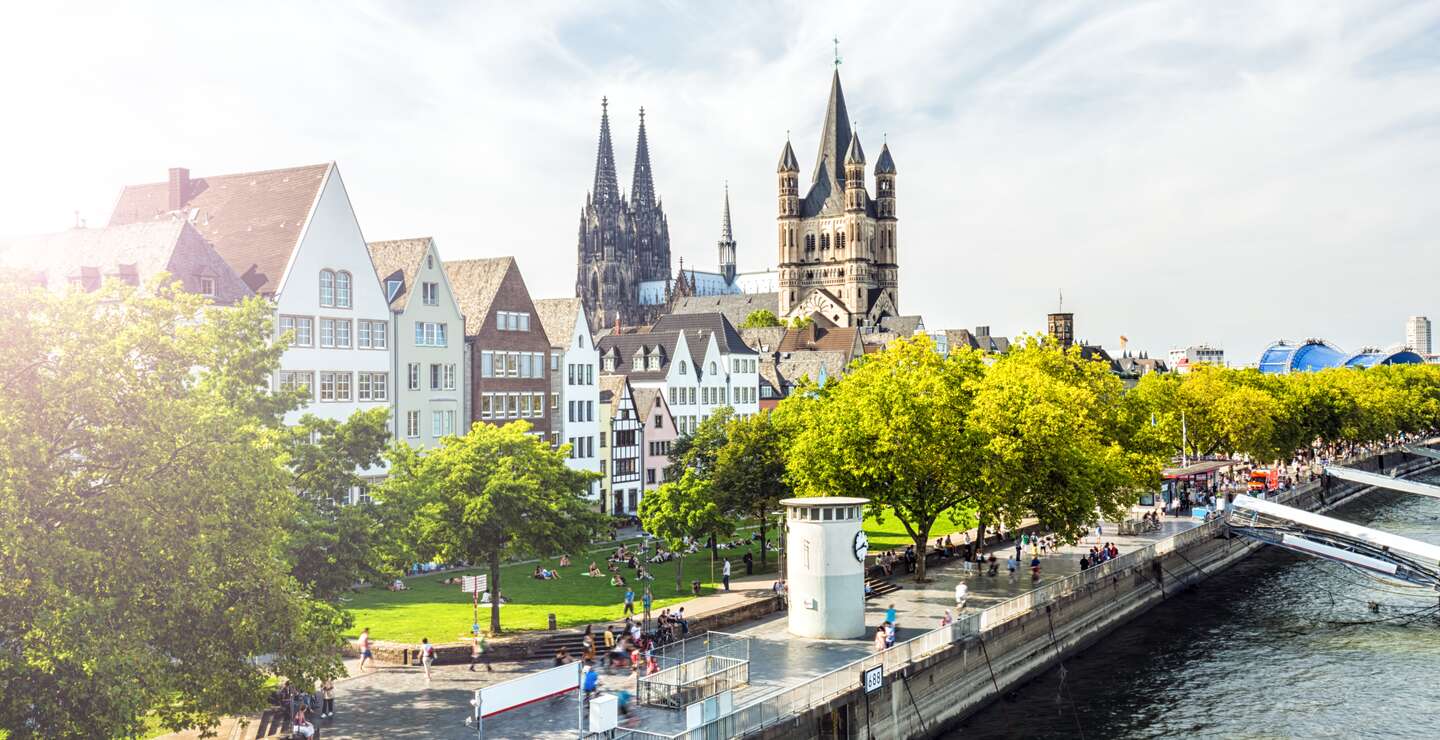 Menschen laufen auf der Rheinpromenade in Köln, der Blick auf die Kölner Altstadt | © Gettyimages.com/querbeet