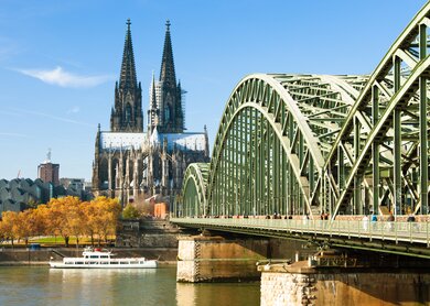 Menschen laufen über die Hohenzollernbrücke im Herbst in Köln, der Blick auf den Kölner Dom | © Gettyimages.com/xenotar