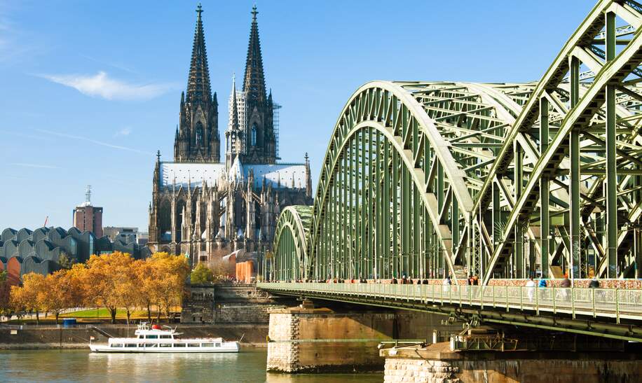 Menschen laufen über die Hohenzollernbrücke im Herbst in Köln, der Blick auf den Kölner Dom | © Gettyimages.com/xenotar