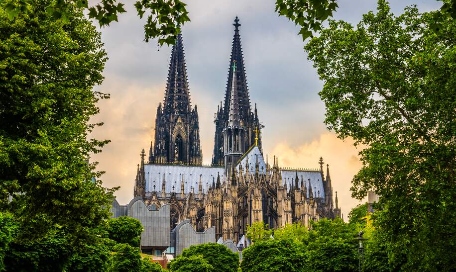 Kölner Dom in Köln, aufgenommen vom Fuße des Doms mit Bäumen im Vordergrund | © Gettyimages.com/Jan de Waal