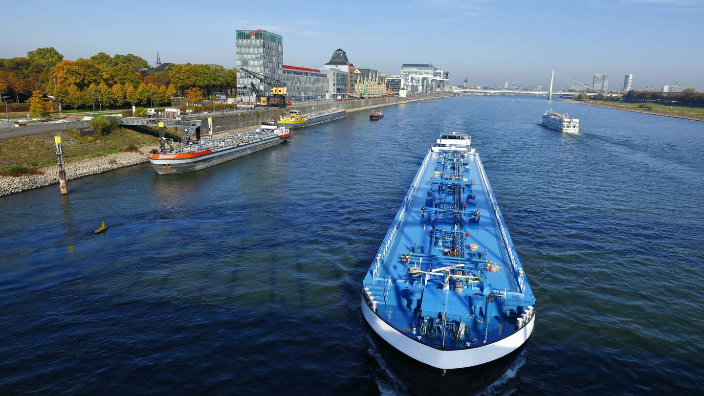 Aufsicht auf ein Schiff am Rheinauhafen in Koeln mit Passagieren bei hellblauem Himmel | © Gettyimages.com/horstgerlach