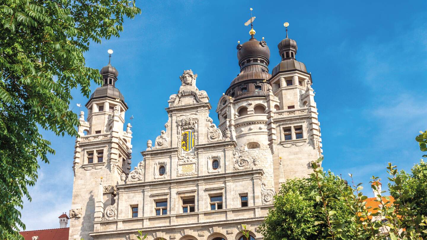 Neues Rathaus in der Stadt Leipzig mit grünen Büschen und Bäumen im Vordergrund | © Gettyimages.com/i_compass