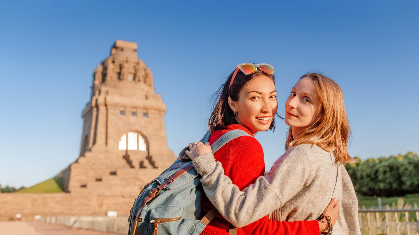 Glückliches Paar, das vor dem Völkerdenkmal in Leipzig an einem sonnigen Tag steht. | © Gettyimages.com/frantic00