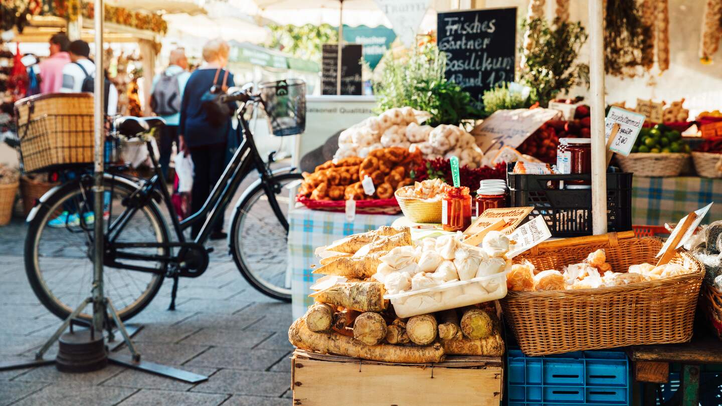 Viktualienmarkt oder großer Bauernmarkt in München, bei Sonnenschein mit vielen Menschen  | © Gettyimages.com/Nikada