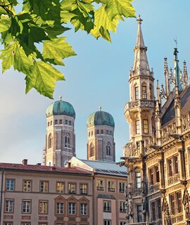 Untersicht auf den marienplatz mit Frauenkirche, Rathaus und Blaettern am oberen Rand des Bildes | © Gettyimages.com/alexsl