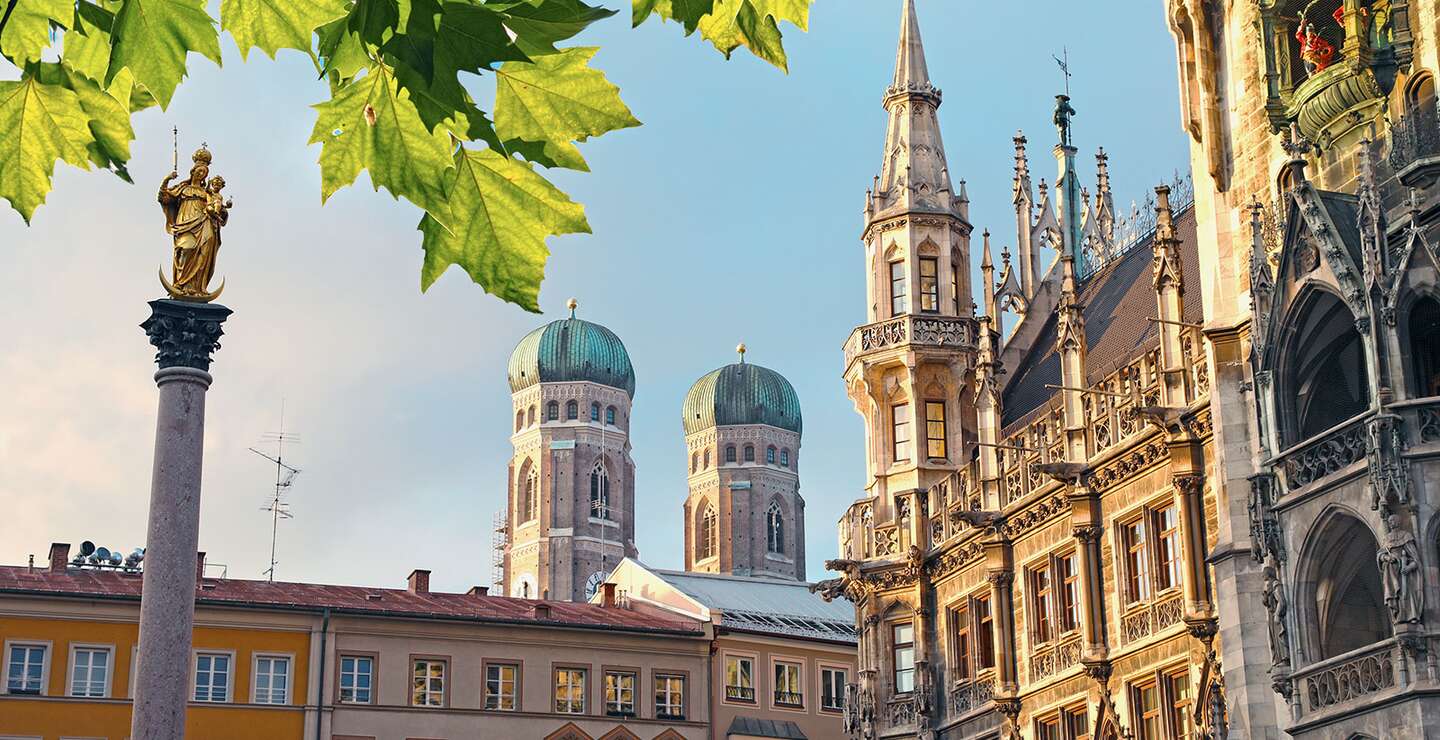 Untersicht auf den marienplatz mit Frauenkirche, Rathaus und Blaettern am oberen Rand des Bildes | © Gettyimages.com/alexsl