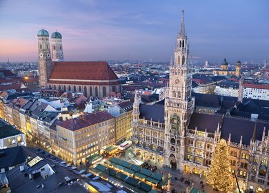 Luftbild vom Marienplatz Muenchen am Rathaus mit beleuchtetem Weihnachtsmarkt am Abend | © Gettyimages.com/RudyBalasko