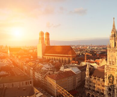 Stadtueberblick von Muenchen mit Frauenkirche und Marienplatz bei Sonnenuntergang | © Gettyimages.com/alexsl