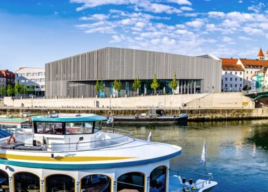 Historische Gebaeude und Passagierschiff in der beruehmten Altstadt von Regensburg an der Donau mit Blick auf das Haus der Bayerischen Geschichte | © Gettyimages.com/FooTToo