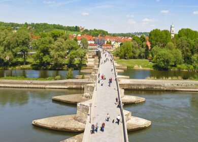 Die alte Steinbruecke (fertiggestellt 1146), ein Wahrzeichen der Stadt Regensburg. | © Gettyimages.com/Leonsbox