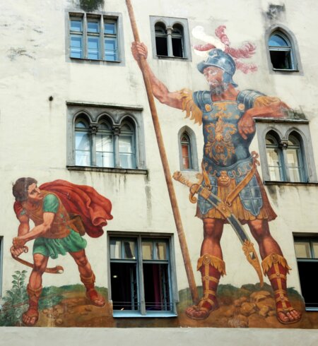 David und Goliath auf der Hausmauer in Regensburg, die zum unesco-Weltkulturerbe gehoeren | © Gettyimages.com/kaetana_istock