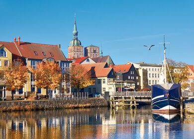 Angedockte Segelboote und Häuser im Kanal mit Backsteintuerme Stralsund | © Gettyimages.com/anyaivanova