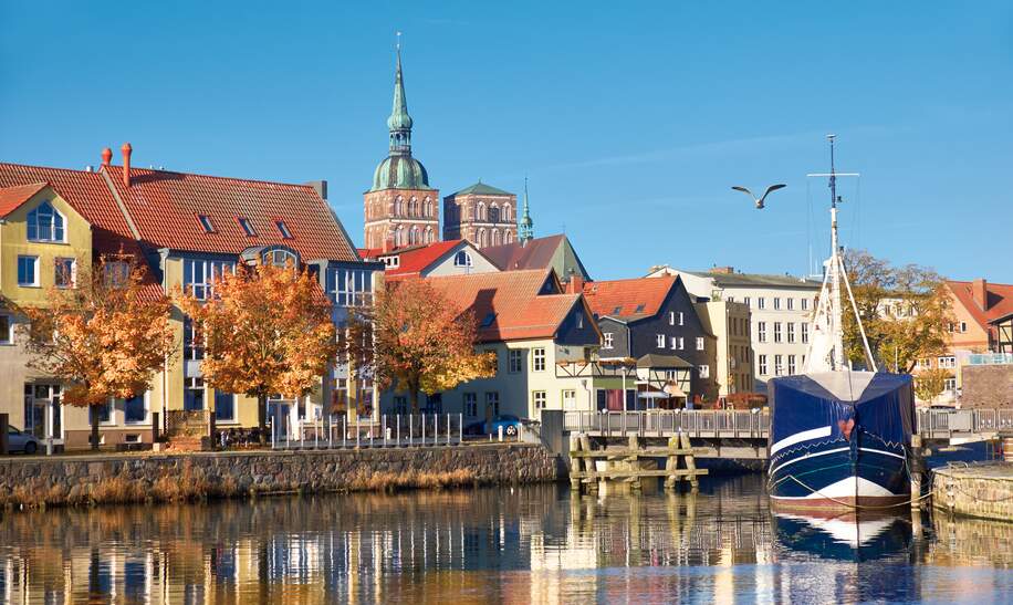 Angedockte Segelboote und Häuser im Kanal mit Backsteintuerme Stralsund | © Gettyimages.com/anyaivanova