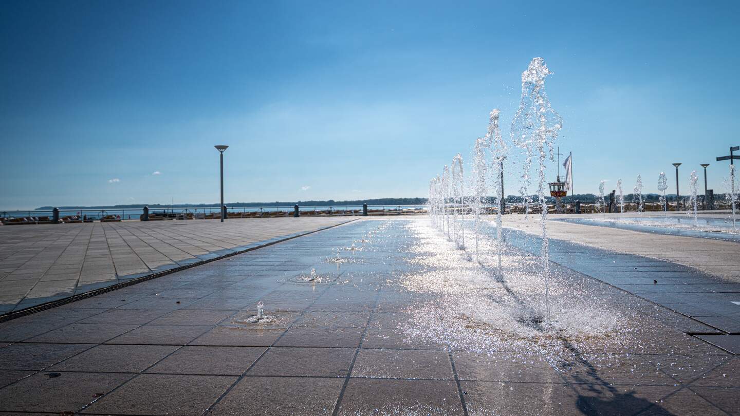 Blick entlang der Sundpromenade der Hansestadt Stralsund auf den Strelasund in Deutschland mit Wasserfontaenen | © Gettyimages.com/undefined undefined