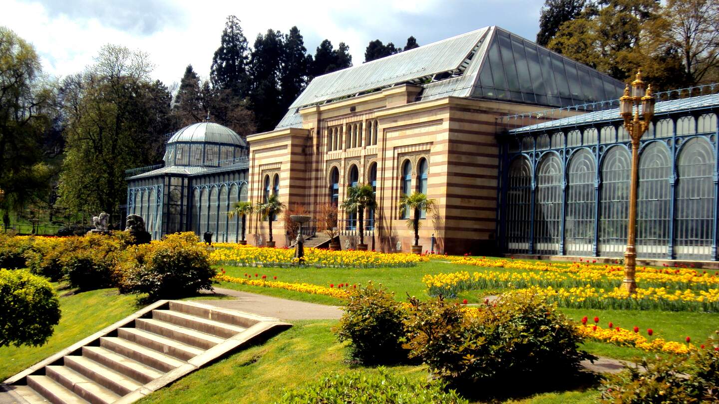 Altes grünes Haus in schöner Gartenanlage im öffentlichen Park Wilhelma mit Frühlingsblumen in Stuttgart | © Gettyimages.com/undefined undefined