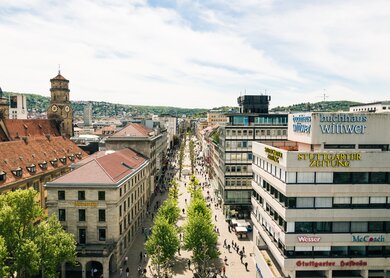Luftaufnahme der Königsstrasse in Stuttgart. Unten laufen Passanten an einem herrlichen Sommertag.   | © Gettyimages.com/nullplus