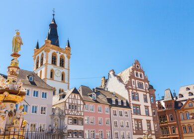 Historische Häuser, Brunnen und Marktkirche am Marktplatz in Trier bei gutem Wetter | © Gettyimages.com/8vFanI