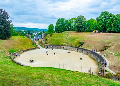Blick auf das alte roemanische Amphitheater in Trier mit einigen Touristen | © Gettyimages.com/trabantos