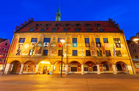Frontale Seitenansicht des beleuchteten Rathauses in Ulm bei Nacht | © Gettyimages.com/saiko3p
