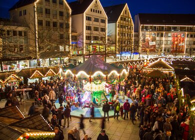 Blick auf den beleuchteten Weihnachtsmarkt in Ulm bei Nacht mit vielen Staenden | © Gettyimages.com/Andreas Bucher