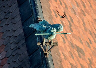 Untersicht auf die Statue des Ulmer Spatzes auf einem Dach | © Gettyimages.com/Andreas Bucher