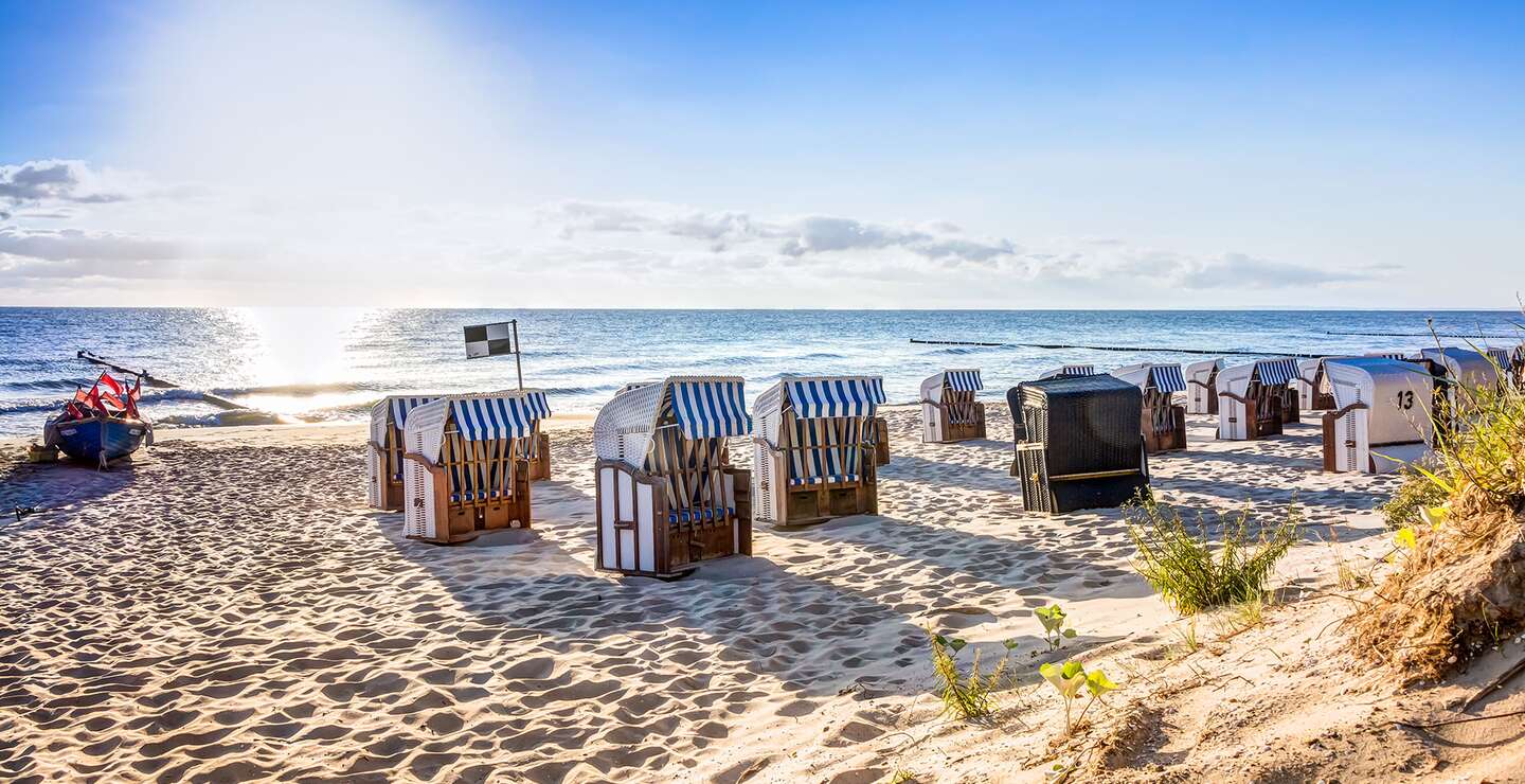  einen Sandstrand mit mehreren traditionellen Strandkoerben, die zum Meer hin ausgerichtet sind | ©  Gettyimages.com/mije_shots