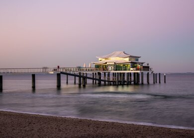 Pier mit Teehaus am Timmendorferstrand im Sonnenuntergang | © Gettyimages.com/sabinewagner