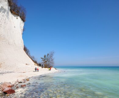 Spaziergaenger an der Kreidefelskueste mit Blick auf das tuerkis blaue Wasser | © Gettyimages.com/hsvrs
