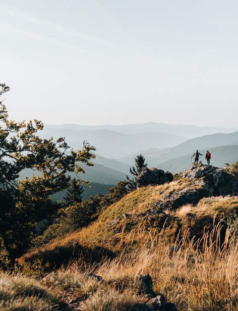 Junges Paar mit dem Rucksack auf einen Berggipfe ueber dem Schwarzwald, Baden-Wuerttemberg | © Gettyimages.com/AscentXmedia