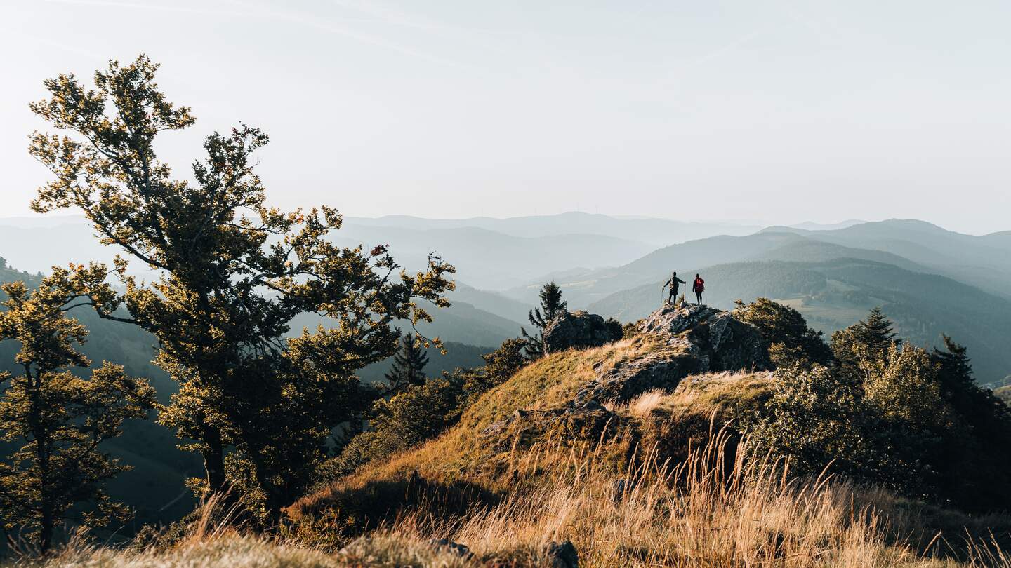 Junges Paar mit dem Rucksack auf einen Berggipfe ueber dem Schwarzwald, Baden-Wuerttemberg | © Gettyimages.com/AscentXmedia