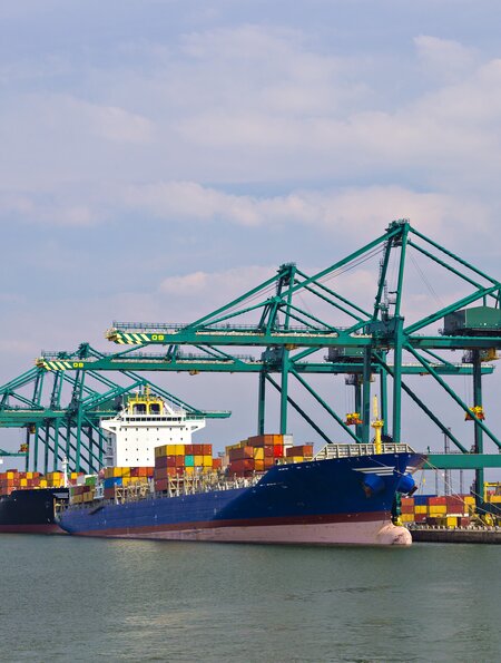 Große Frachtschiffe werden im Containerhafen Antwerpen von Kranichen (syn. großer Kran) beladen | © Gettyimages.com/Serbek