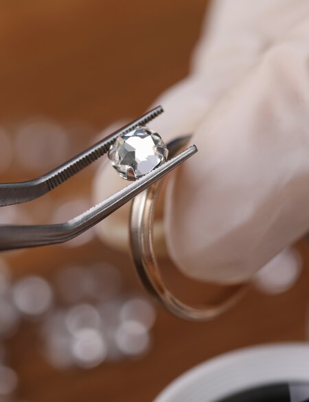 Juwelier in Antwerpen/Belgien haelt einen Diamantenring mit Pinzette | © Gettyimages.com/Ivan-balvan