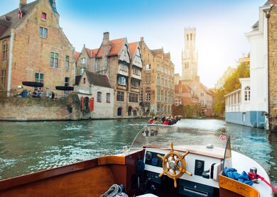 Ein Ausflugsboot fährt auf dem Rozenhoedkai mit Blick auf den Belfried in Bruegge. | © Gettyimages.com/ArtMarie