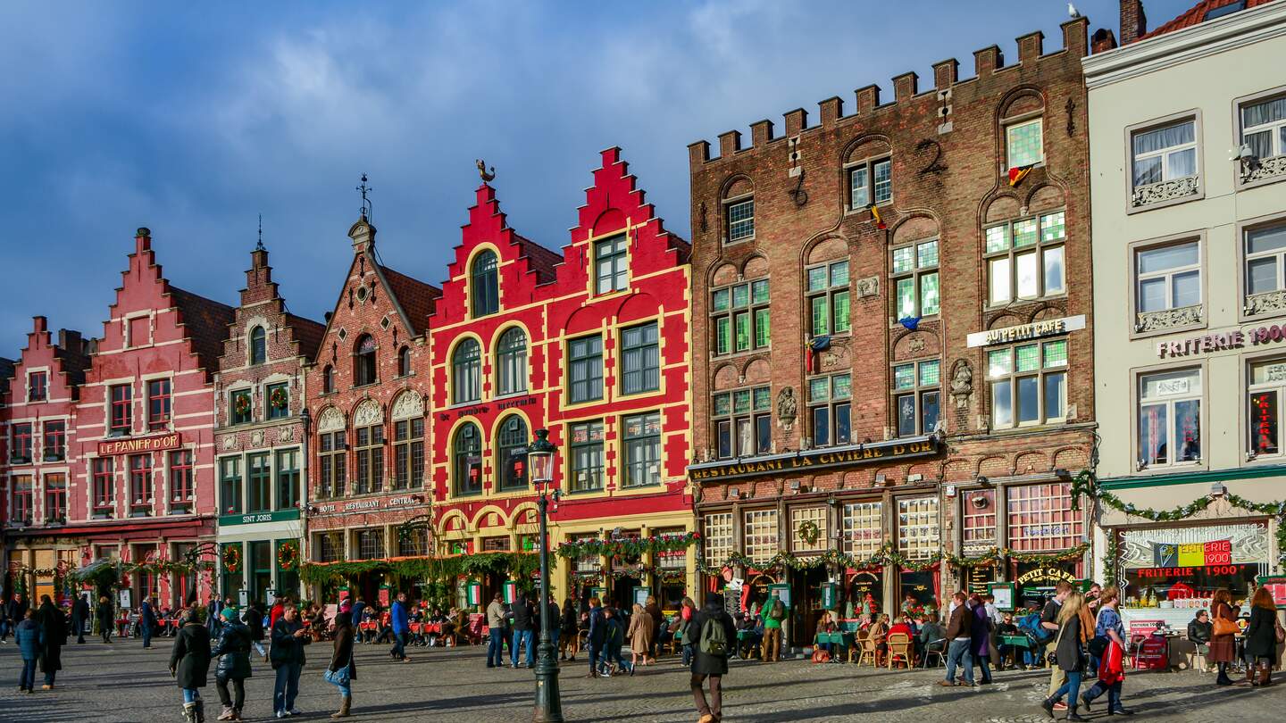 Gebaeude im mittelalterlichen Stil in der Naehe des Marktplatzes (Grote Markt) in Bruecke Menschen flanieren auf dem Platz. | © Gettyimages.com/HIT1912